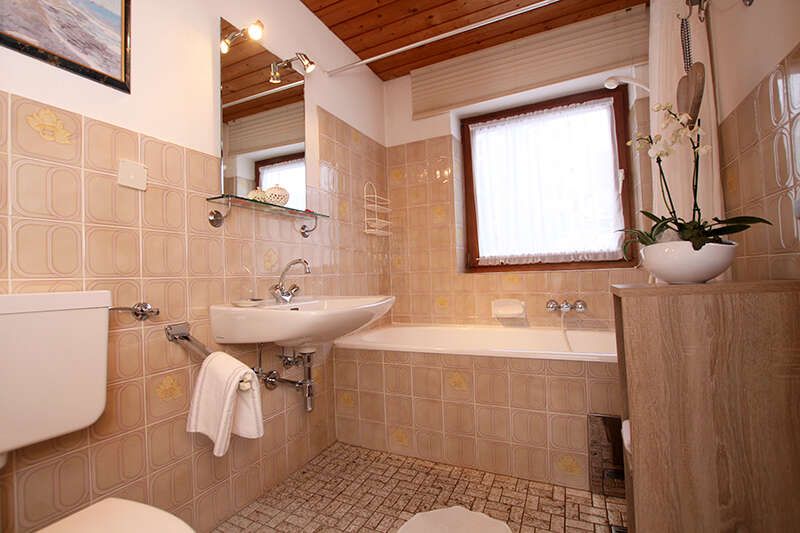 Badezimmer mit WC und Wanne im Haus Alice